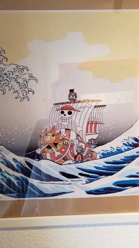 Wandbild im Gastraum mit stilisierter Welle und einem Segelschiff